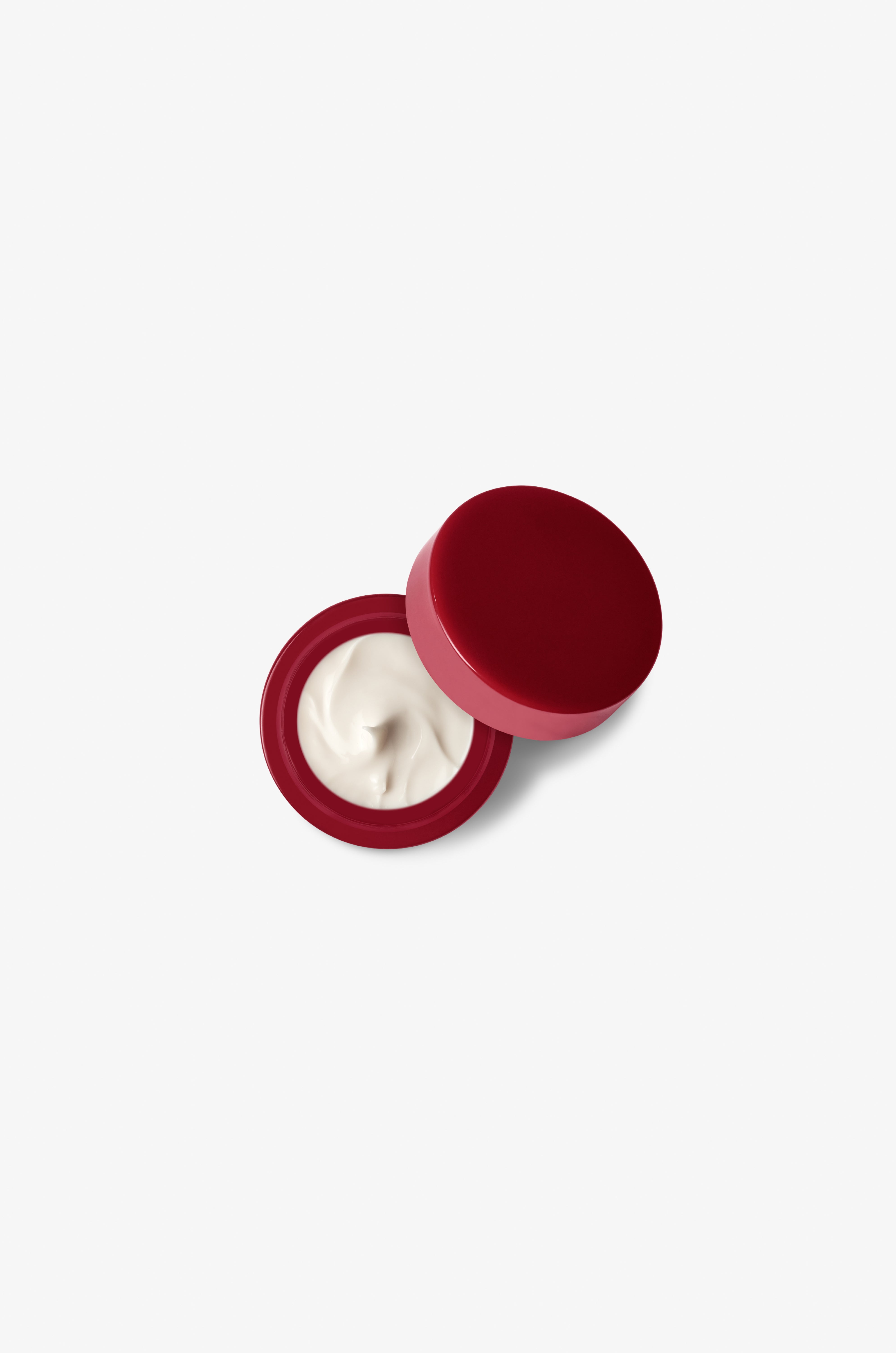 Red container with white cream on a white background