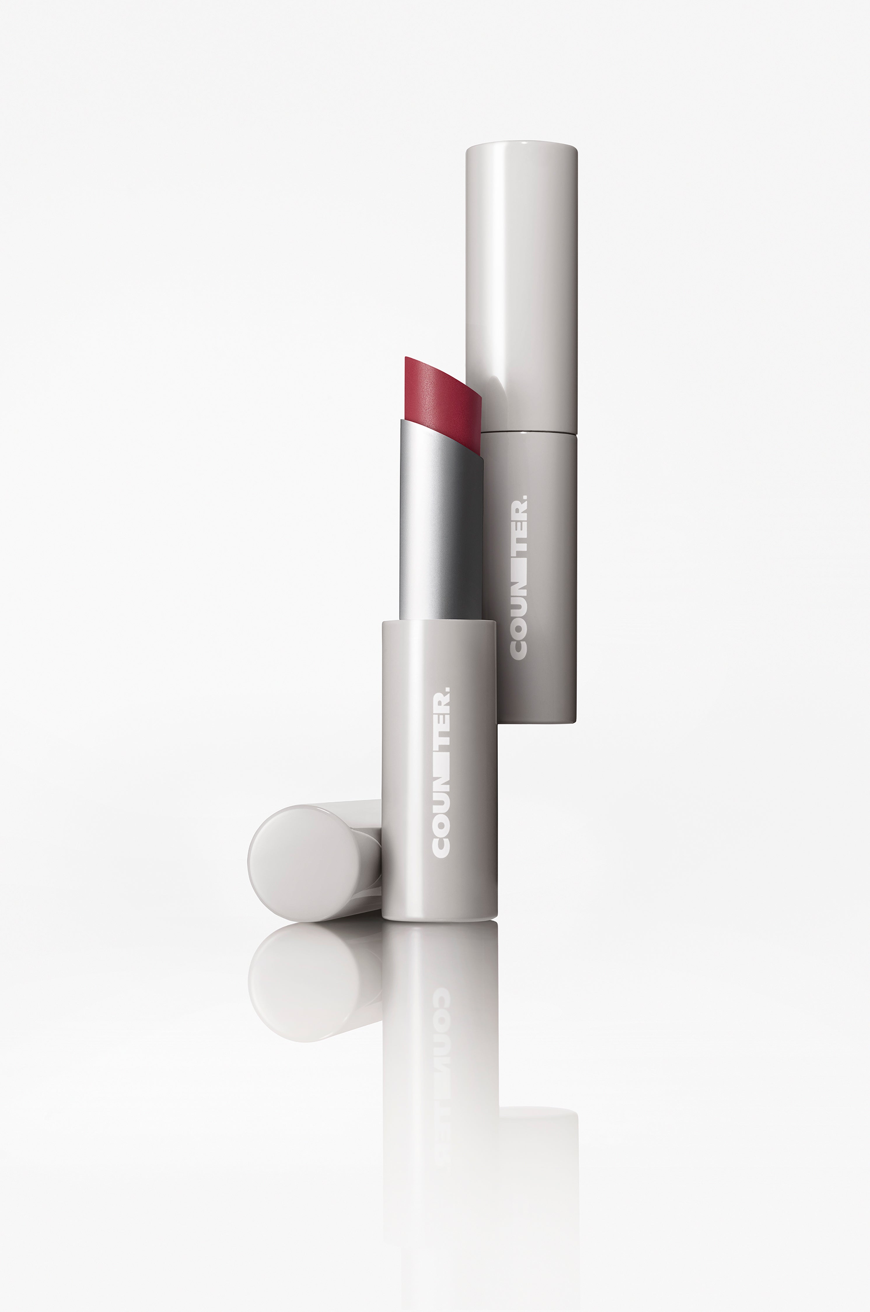 Lipstick with white casing and red cap on a white background