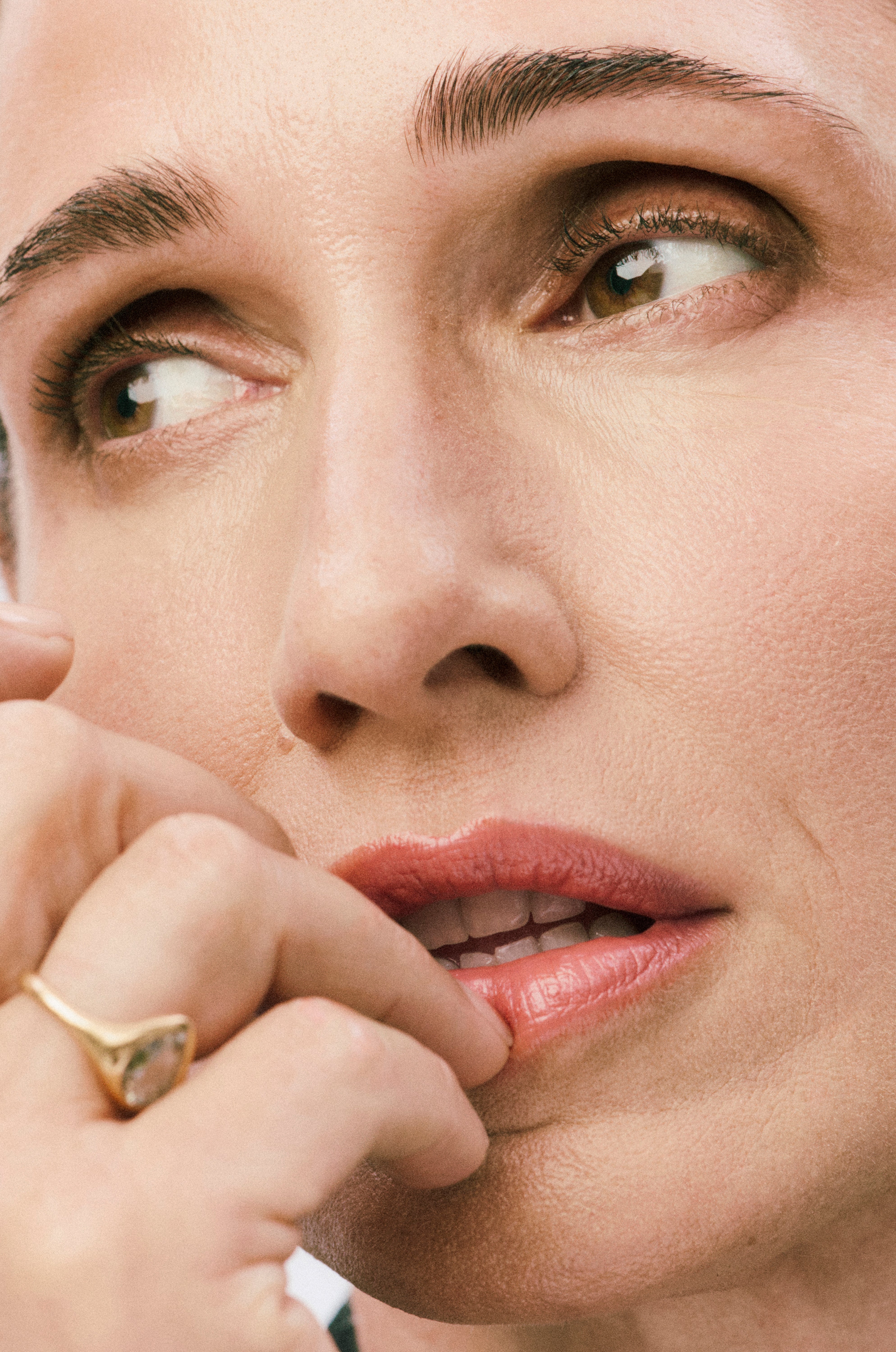 Displays close up of a model's face wearing Skin Twin Featherweight foundation in shade 340.