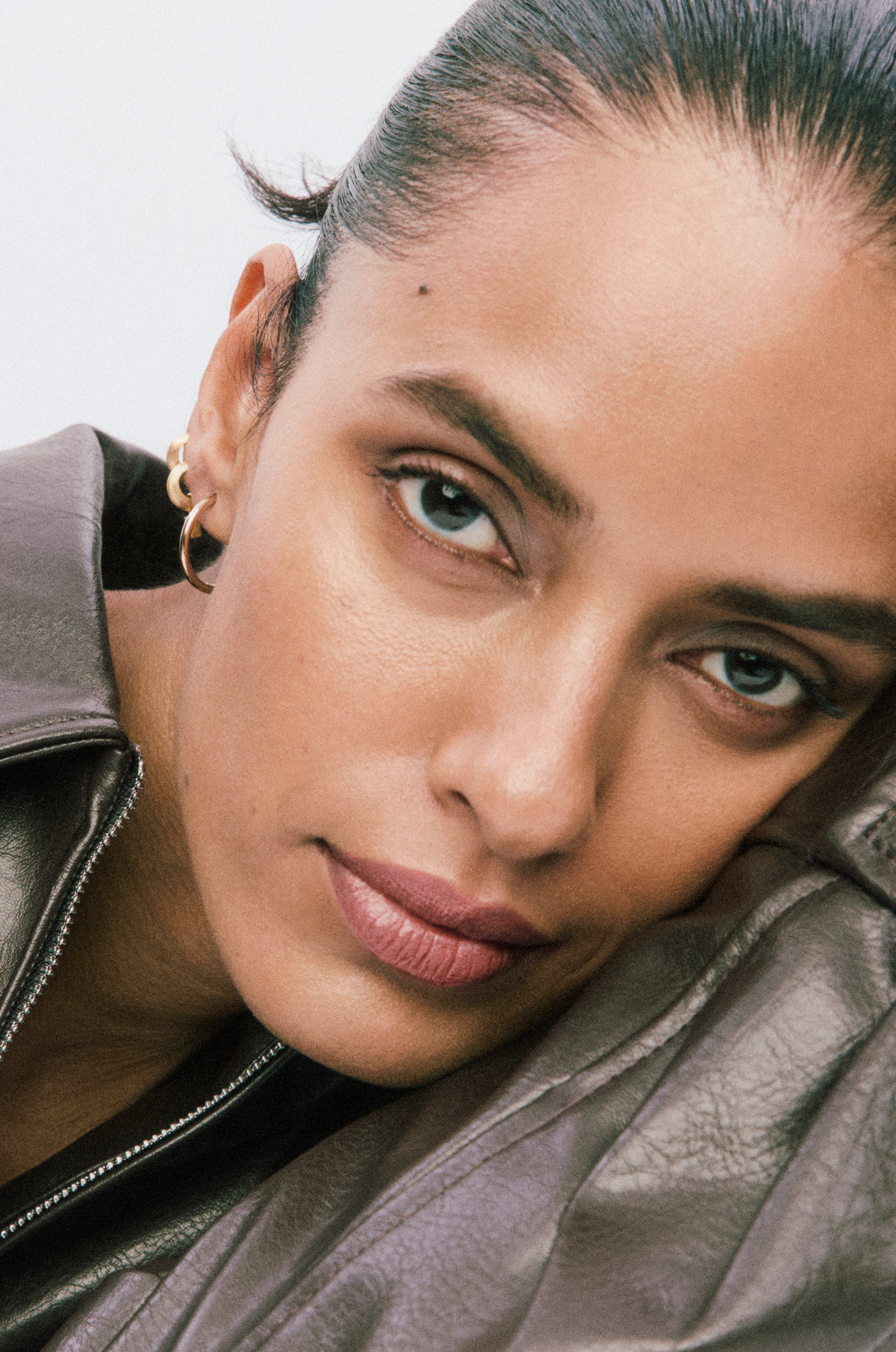 Displays a close up of a model's face. She is wearing Skin Twin Featherweight foundation.