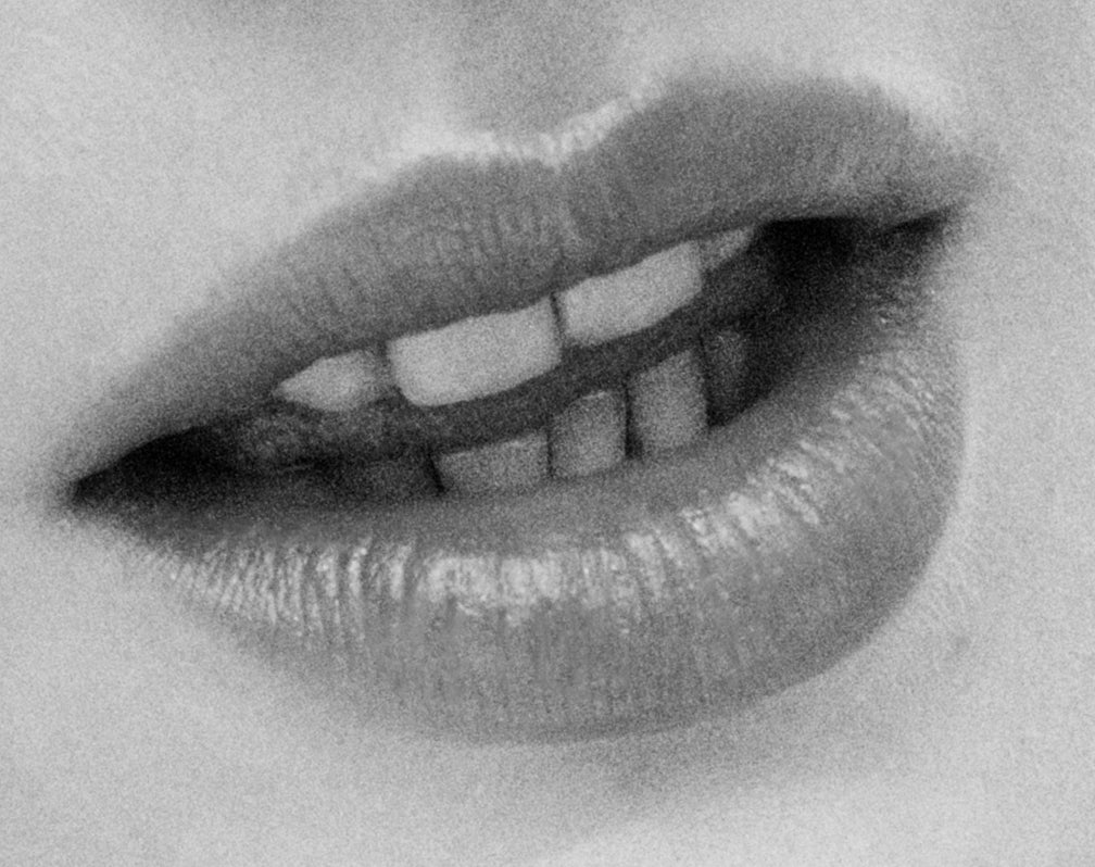 Displays a close up of a woman's open mouth.