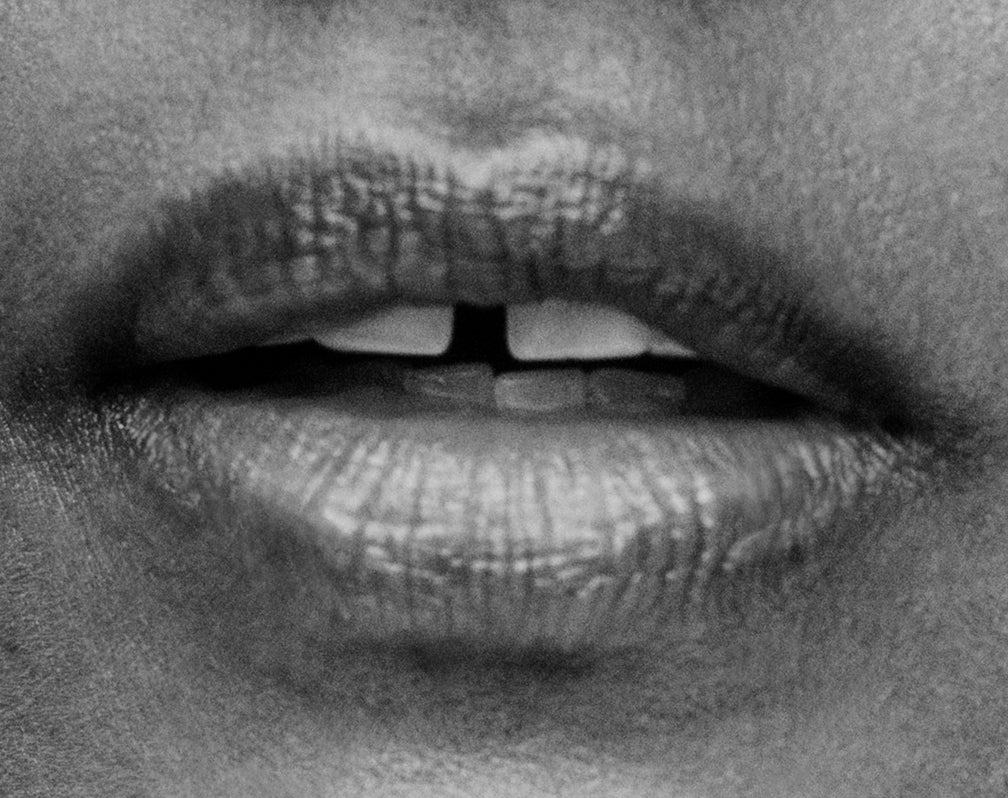 Displays a close up of a woman's open mouth.