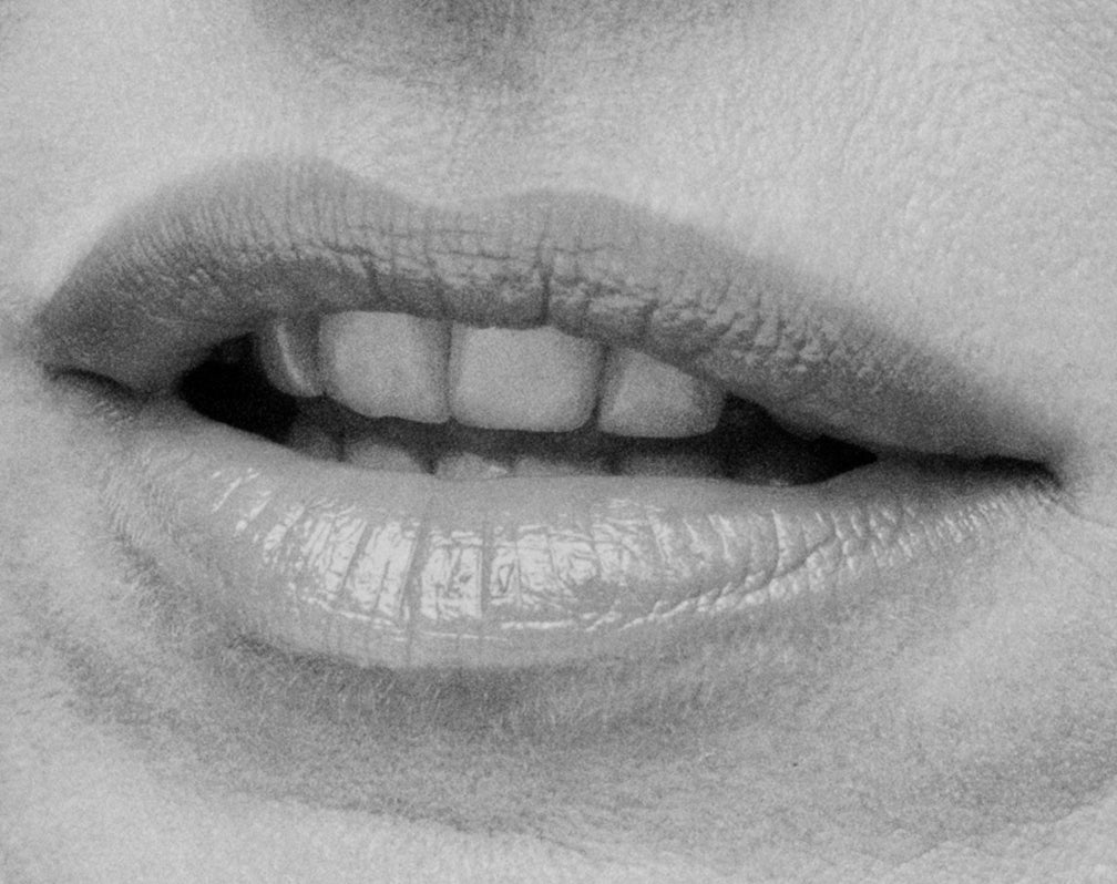 Displays a close up of a woman's open mouth.