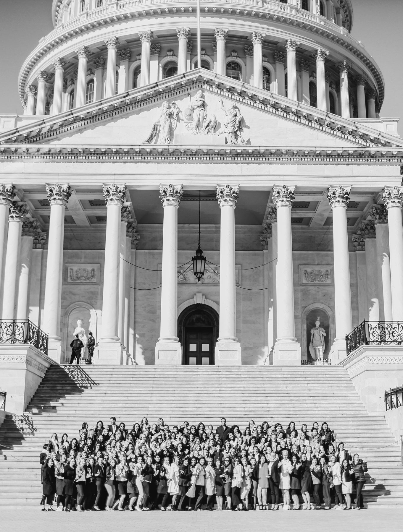 Displays Gregg Renfrew with a group of women posing for a photo on the steps of the Capitol building in Washington DC.