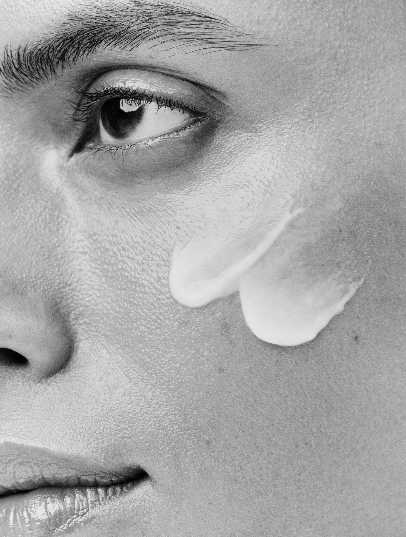 Displays a close up of a model's face with white Counter product applied on her cheek.