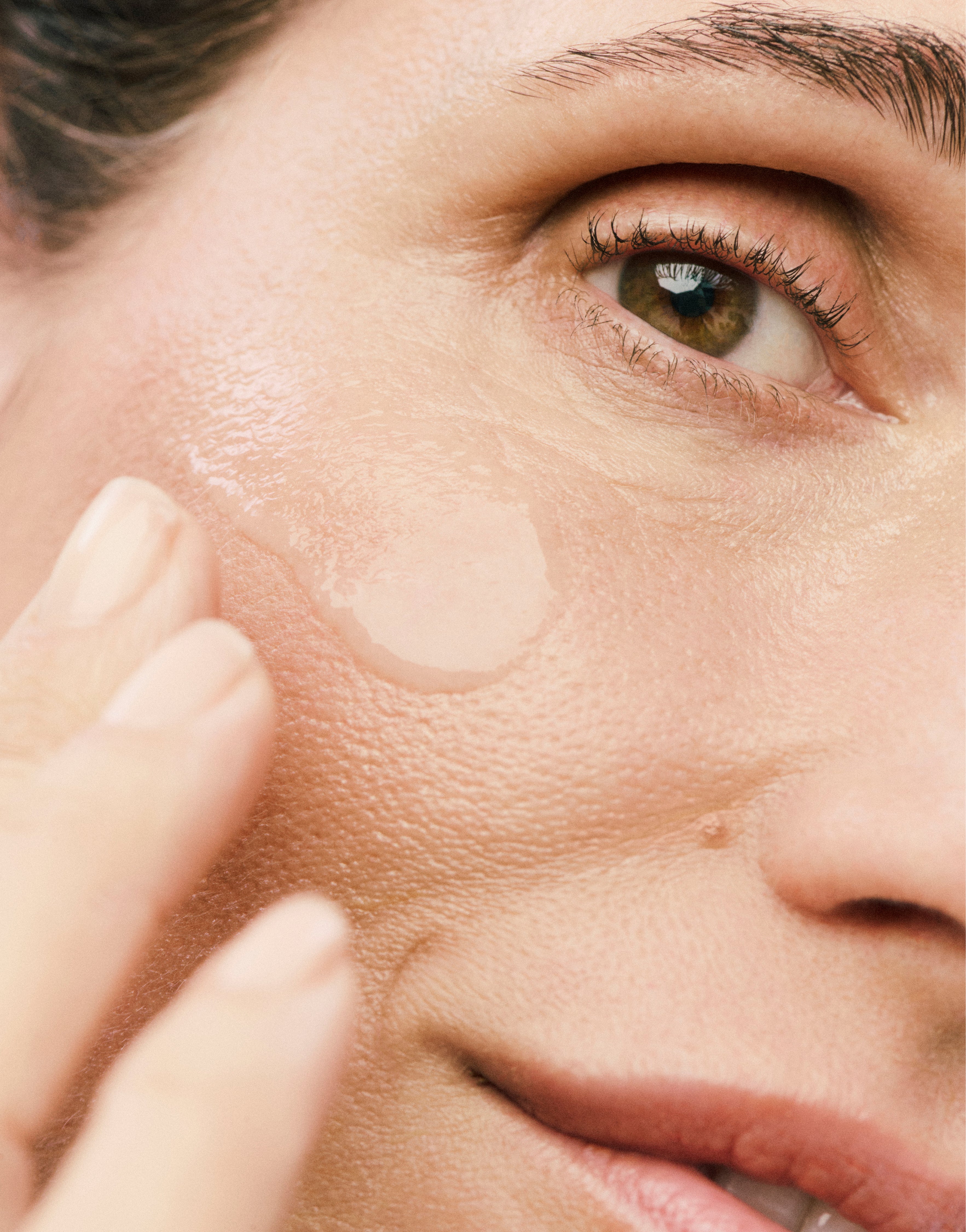 Displays a close up of half of a model's face with a Counter Product smear on her cheekbone. 
