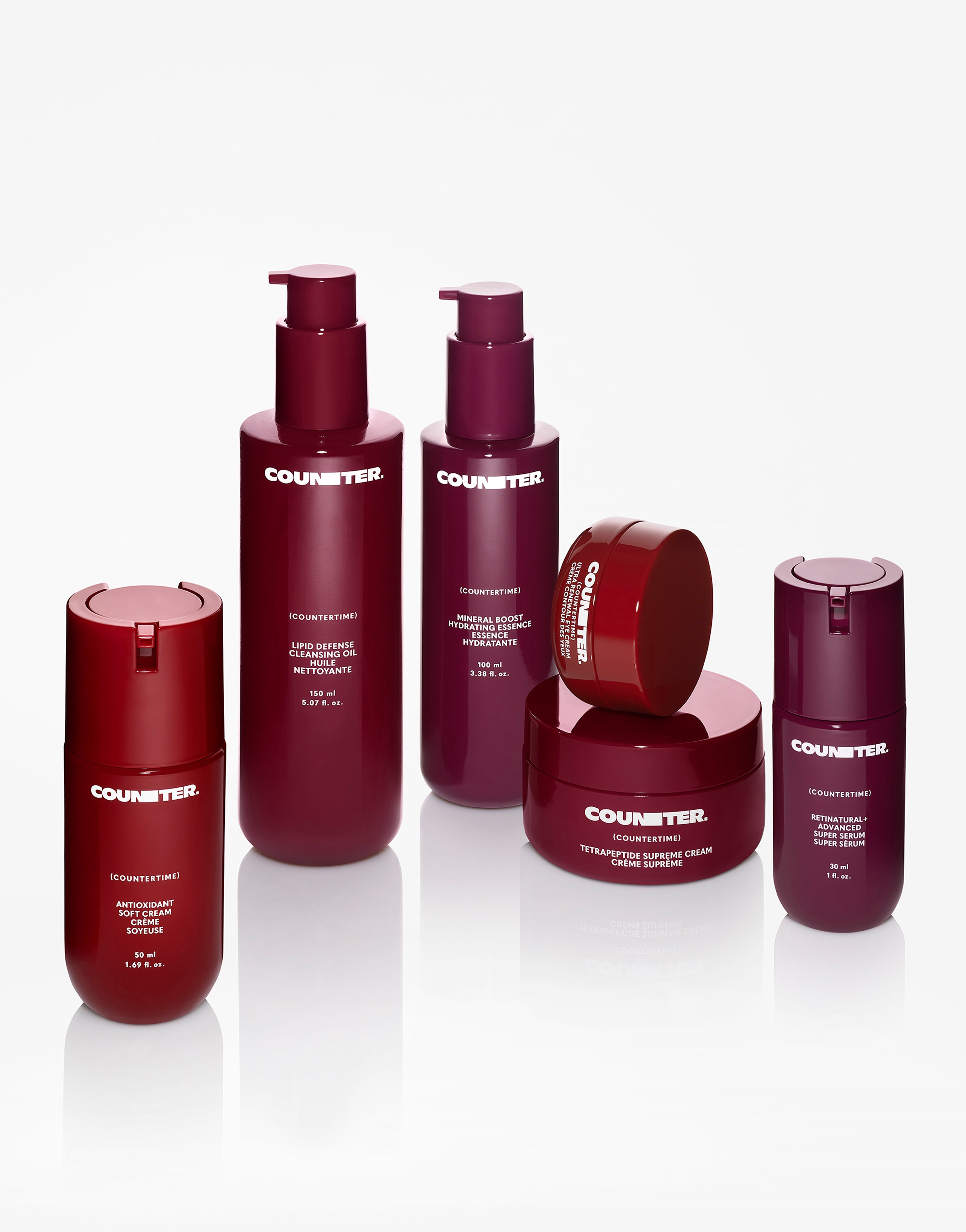Displays the Counter "Countertime" Line all staggered on a mirrored surface. All of the bottles are varying degrees of red and burgundy. 